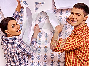 Family glues wallpaper at home