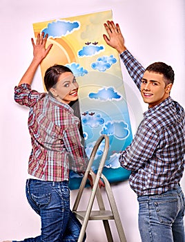 Family glues wallpaper at home