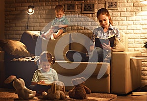 Family before going to bed mother and children read books and pl