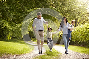 Family Going For Walk In Summer Countryside