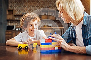 Curly haired boy talking with grandma at table