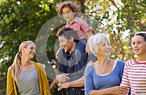Family, grandparent and fun in nature, happy and bonding children smile in park and walking. Parents, kid on shoulder
