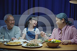 family grandparent and granddaughter dining on table and having fun during at