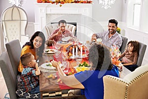 Family With Grandparents Enjoying Thanksgiving Meal At Table