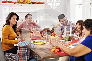 Family With Grandparents Enjoying Thanksgiving Meal At Table