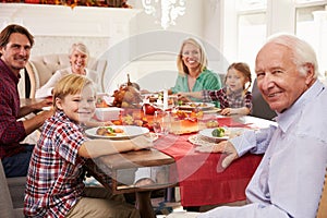 Family With Grandparents Enjoying Thanksgiving Meal At Table