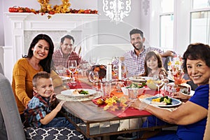 Family With Grandparents Enjoying Thanksgiving Meal At Table photo