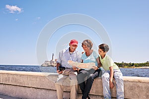 Family Grandparents Reading Tourist Map In Habana Cuba