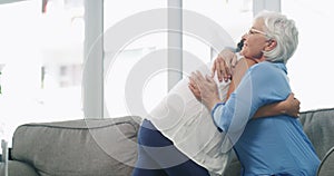 Family, greeting and a grandma hugging her girl grandchild on a sofa in the living room during a visit together. Love