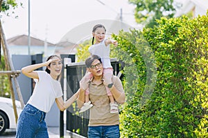 Family group of Asian people happy together outdoors with child enjoying playful fun to explorer