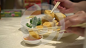 Family hands chopsticks eating fried tofu with salt and pepper vegan healthy food Hong Kong Chinese cuisine 4k
