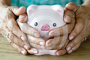 Family hands covering lovely piggy bank
