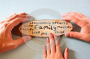 Family hands holding sign with the word family