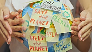 Family hands hug Earth globe with stickers