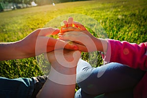 Family hands- mom, son and daughter- at sunset, parenting