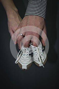 Family hands, mother and father hand holding newborn baby booties