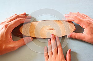 Family hands showing wooden blank sign. room for text
