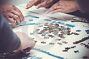 Family hands solving jigsaw