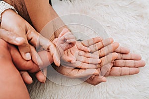 Family hands are stacking hands under the baby& x27;s hand