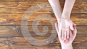 Family hands on wooden table, top view. Team concept