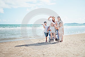 Family happily chatted with Grandma on the beach wheelchair