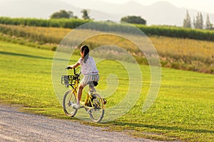 Family Happy.  Asia gird happy and relax outdoor with bicycling at the garden meadow in sunset photo