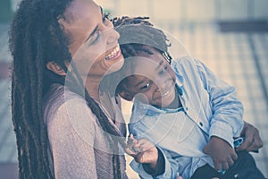 Family happy and playful time together - mother and son black african race people have fun at the park - love for mother and young