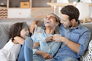 Family have fun daughter and daddy tickling mother