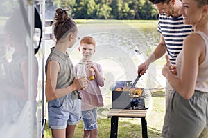 Family having barbecue during camper trip