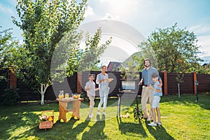 family having barbecue together on backyard