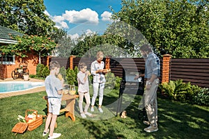 family having barbecue together on backyard