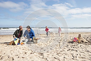 Family Having Barbeque On Winter Beach