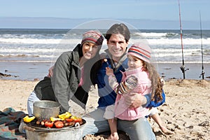 Family Having Barbeque On Winter Beach