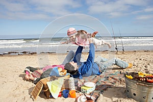 Family Having Barbeque On Winter Beach
