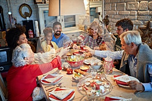 Family having Christmas dinner at home with happy friends