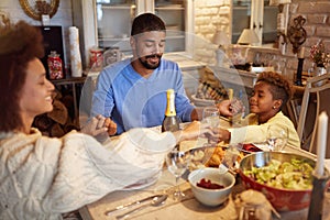 Family having Christmas prayer for dinner at home