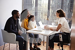 Family Having Consultation With Female Pediatrician In Hospital Office