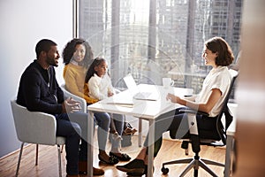 Family Having Consultation With Female Pediatrician In Hospital Office