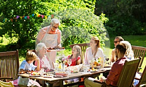 Family having dinner or barbecue at summer garden