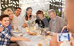 Family having dinner party and taking selfie