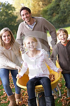 Family having fun with autumn leaves in garden