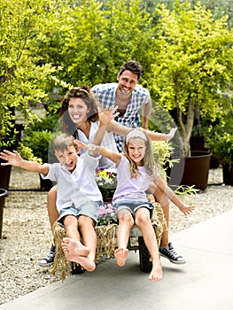 Family having fun with a barrow in a greenhouse