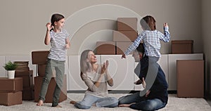 Family having fun dance laughs enjoy moving to new house