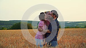 Family having fun in the field at sunset. Summer wheat harvest. Happy family father, mother and child daughter launch a