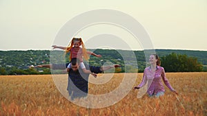 Family having fun in the field at sunset. Summer wheat harvest. Happy family father, mother and child daughter launch a
