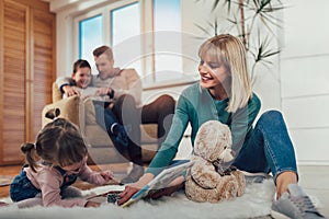 Family having fun on floor of in living room at home, laughing
