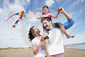 Familia divirtiéndose volador ey sobre el Playa día festivo 