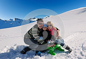 Family having fun on fresh snow at winter vacation