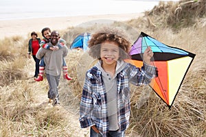 Family Having Fun With Kite In Sand Dunes