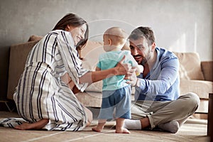 Family is having fun playing with a baby at home